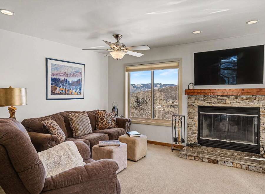 This stunning living room boasts a cozy fireplace and a large TV, perfect for relaxing evenings.