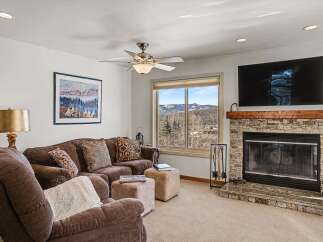 This stunning living room boasts a cozy fireplace and a large TV, perfect for relaxing evenings.