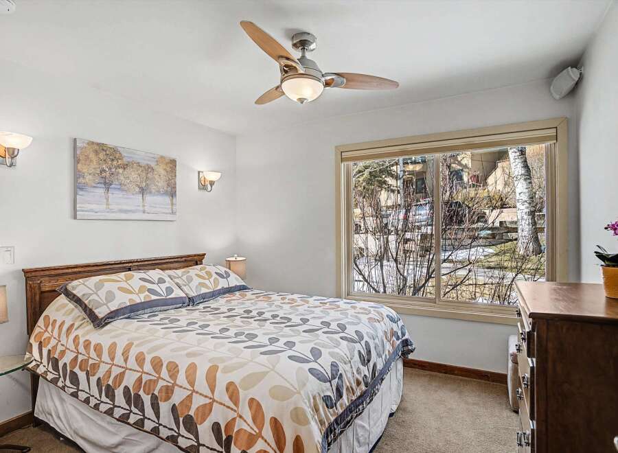 This inviting bedroom features a comfortable bed with stylish bedding, perfect for a relaxing retreat.