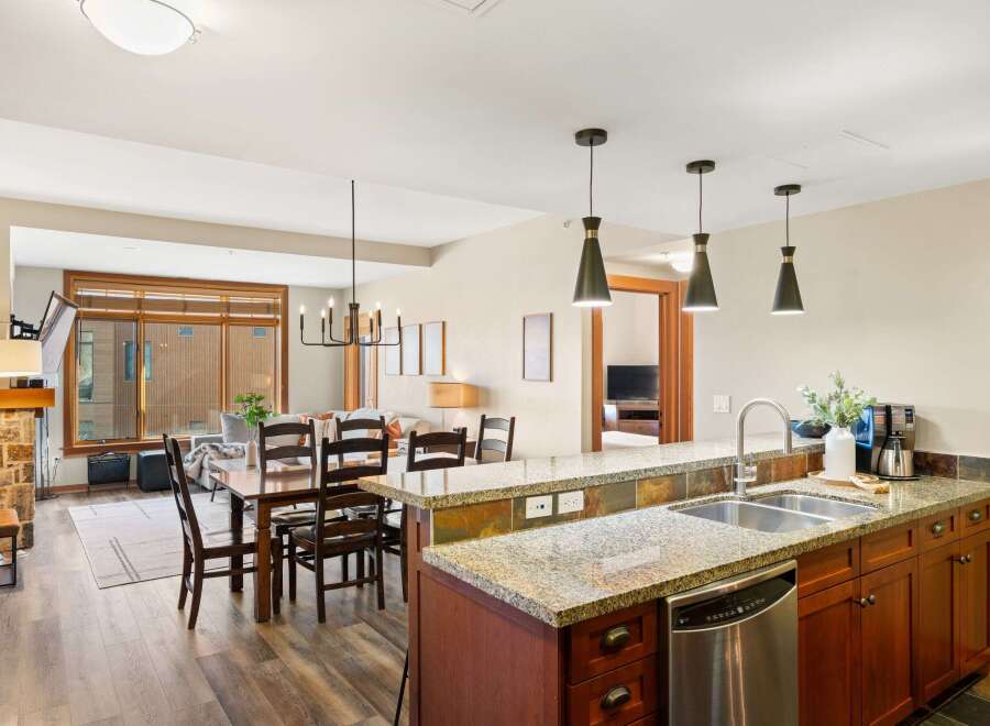 This stunning kitchen boasts granite countertops, stainless steel appliances, and rich wood cabinetry, creating a luxurious and functional space.