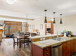 This stunning kitchen boasts granite countertops, stainless steel appliances, and rich wood cabinetry, creating a luxurious and functional space.
