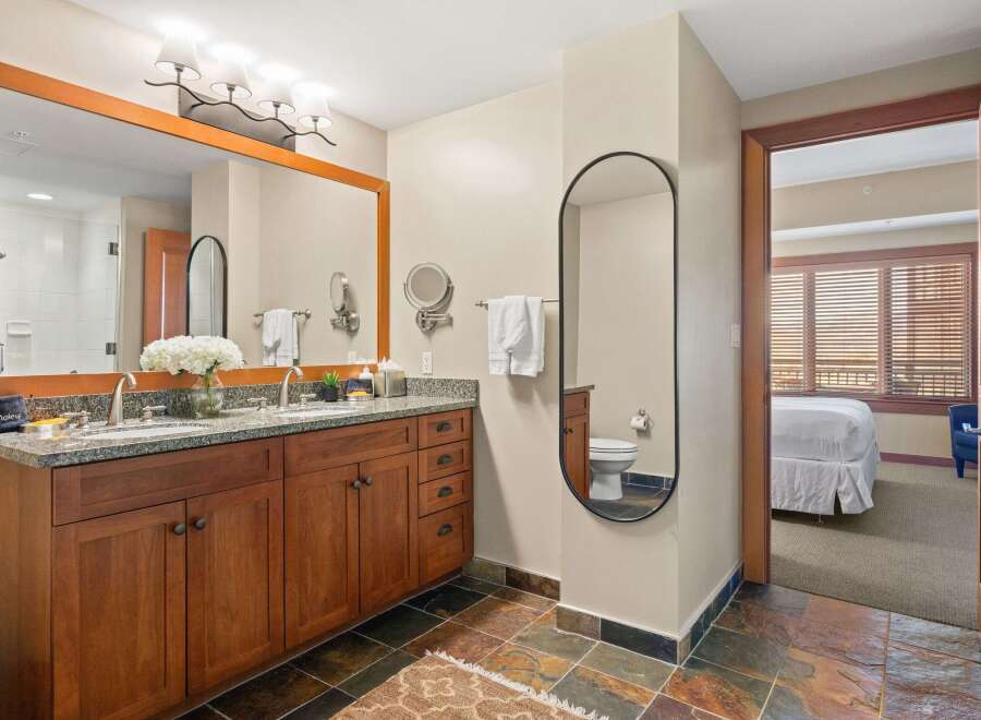 This luxurious bathroom features a double vanity with a granite countertop and ample storage.