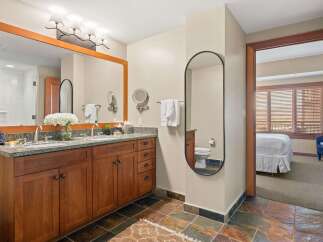 This luxurious bathroom features a double vanity with a granite countertop and ample storage.