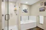 Step into a serene bathroom retreat, featuring a modern shower and a relaxing bathtub.