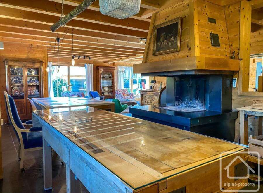 This stunning property boasts a warm and inviting interior with exposed wooden beams and a cozy fireplace, perfect for creating a relaxing atmosphere.