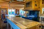 This stunning property boasts a warm and inviting interior with exposed wooden beams and a cozy fireplace, perfect for creating a relaxing atmosphere.