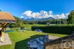 Discover the charm of this stunning property, boasting a lush green lawn and breathtaking mountain views.