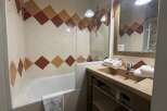 This charming bathroom features a stylish design with diamond-patterned tiles in warm tones.