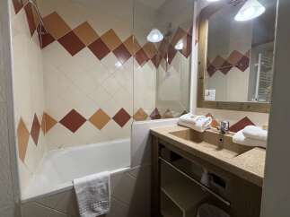 This charming bathroom features a stylish design with diamond-patterned tiles in warm tones.