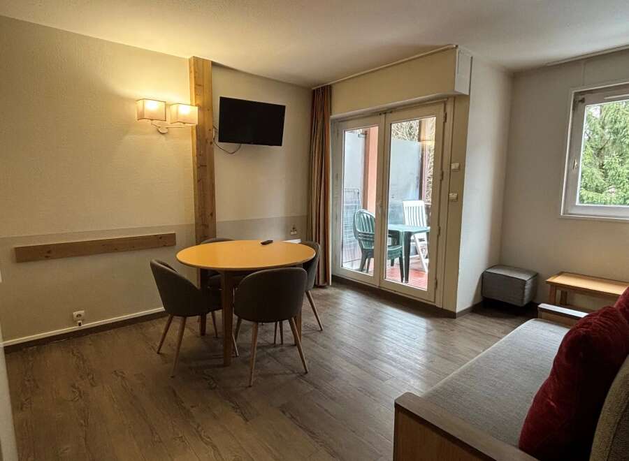 Discover this inviting property featuring a cozy dining area with a round table and comfortable chairs, perfect for meals or gatherings.