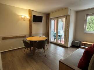 Discover this inviting property featuring a cozy dining area with a round table and comfortable chairs, perfect for meals or gatherings.