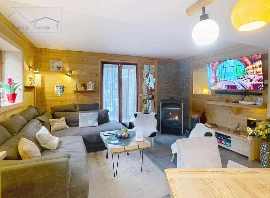 Step into this cozy living space, featuring a warm wooden interior and a welcoming fireplace.
