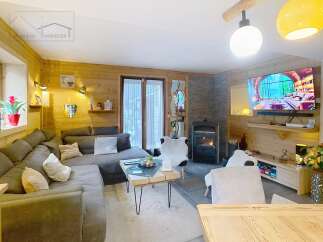 Step into this cozy living space, featuring a warm wooden interior and a welcoming fireplace.