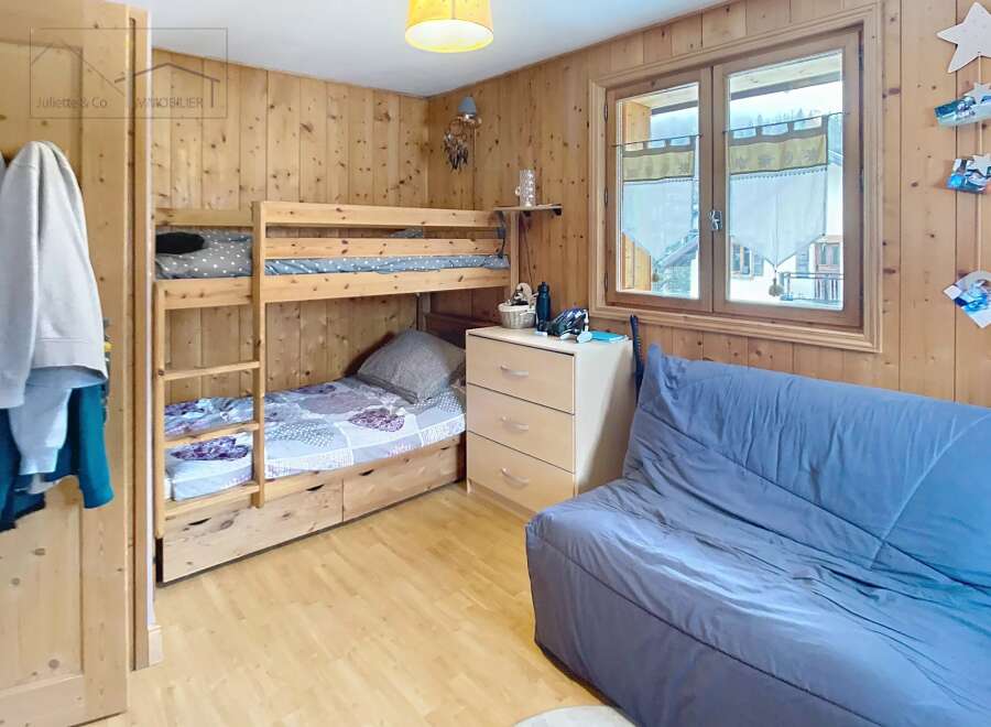 Discover the charm of this cozy bedroom featuring a wooden bunk bed, perfect for accommodating guests or family.