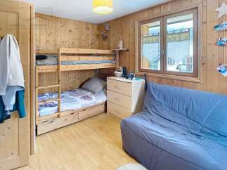 Discover the charm of this cozy bedroom featuring a wooden bunk bed, perfect for accommodating guests or family.