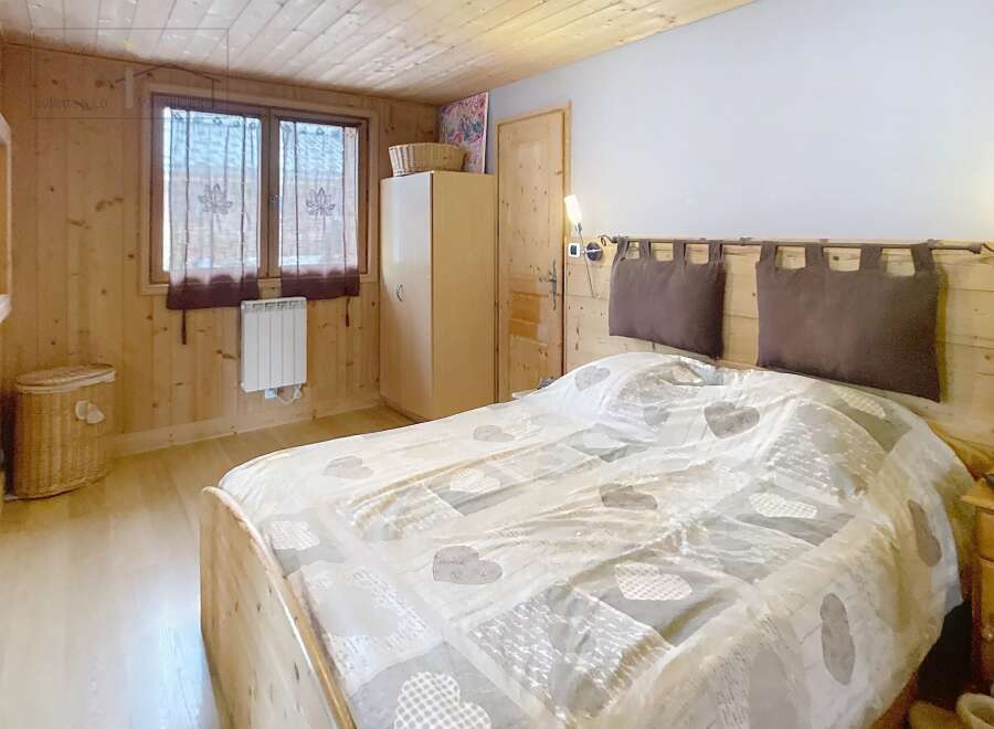 This cozy bedroom features a warm wooden interior, creating a rustic and inviting atmosphere.