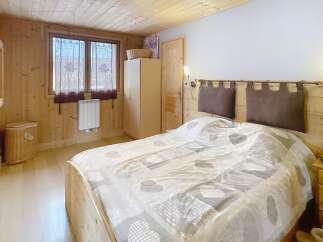 This cozy bedroom features a warm wooden interior, creating a rustic and inviting atmosphere.