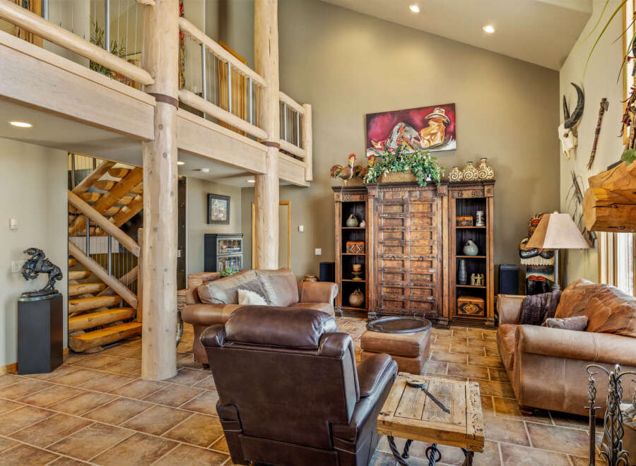 Step into luxury with this stunning property, featuring a spacious living area with exposed wooden beams and a cozy fireplace.