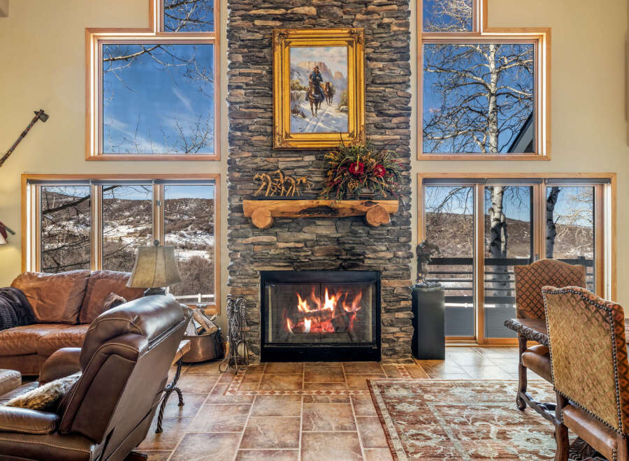 Experience the warmth and charm of this stunning living space, featuring a beautiful stone fireplace as the focal point.