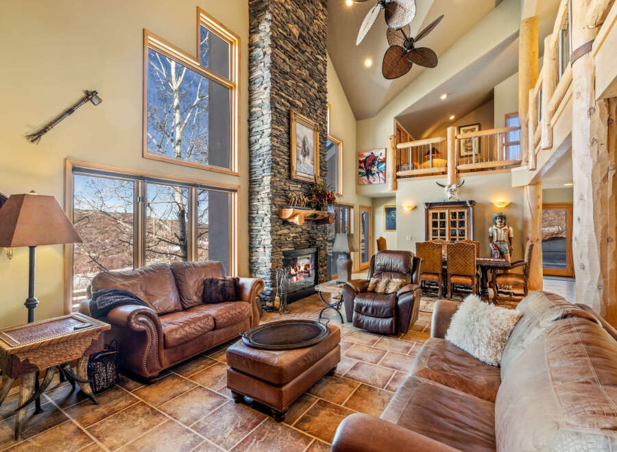 This stunning living room boasts a grand stone fireplace, creating a cozy ambiance.