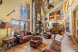 This stunning living room boasts a grand stone fireplace, creating a cozy ambiance.