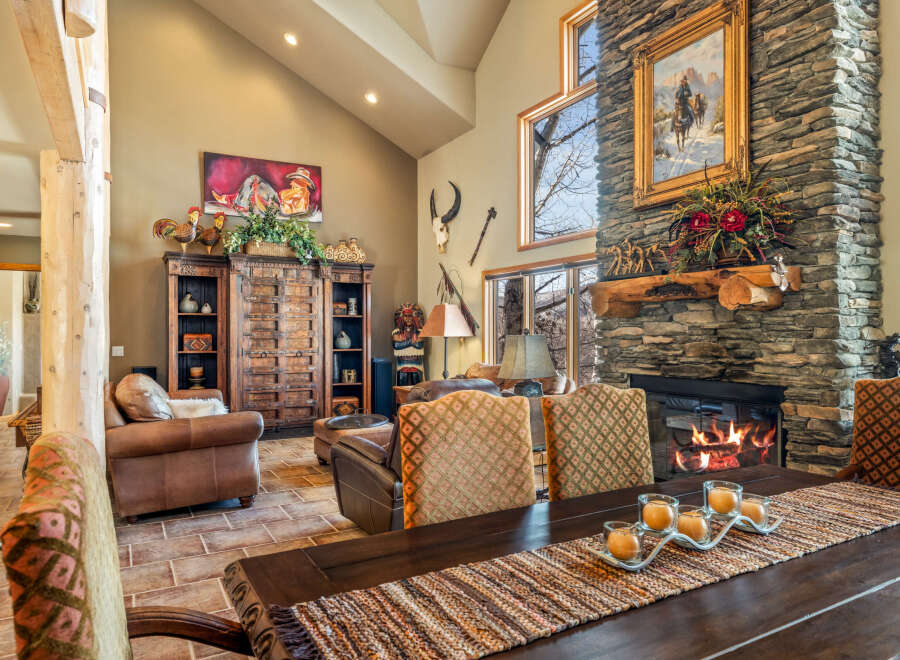 This stunning living room boasts a rustic charm with its stone fireplace and exposed wooden beams.