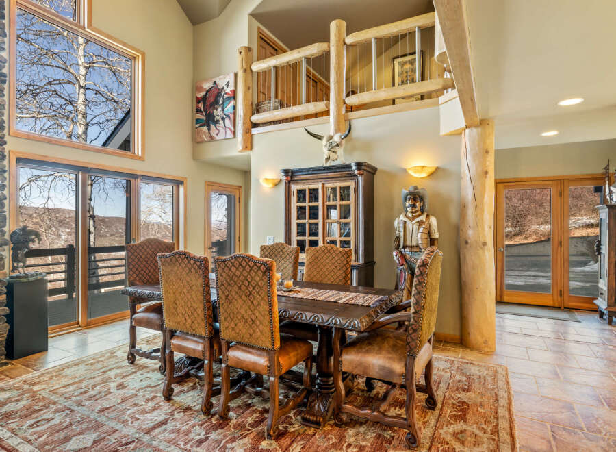 Step into luxury with this stunning dining room, featuring a grand wooden dining table and elegant chairs.