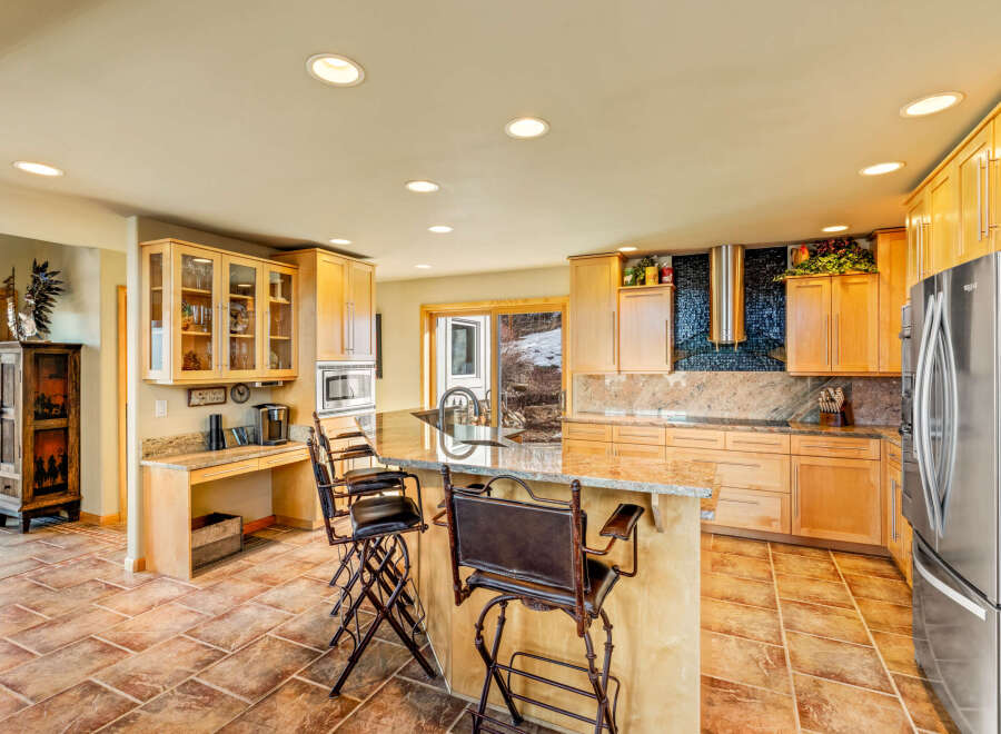 This stunning kitchen boasts a spacious layout with ample counter space and storage, perfect for culinary enthusiasts.