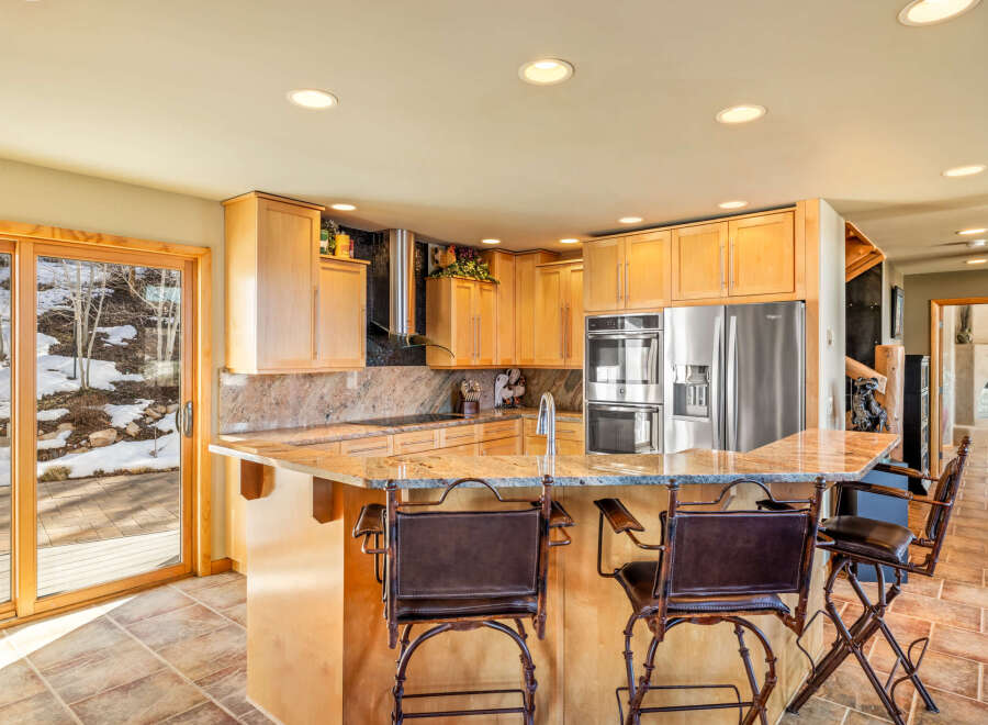 This stunning kitchen boasts a spacious layout with a beautiful granite countertop island, perfect for entertaining.