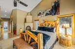 Experience rustic luxury in this stunning bedroom, featuring a unique log-style bed frame and a cozy fireplace.