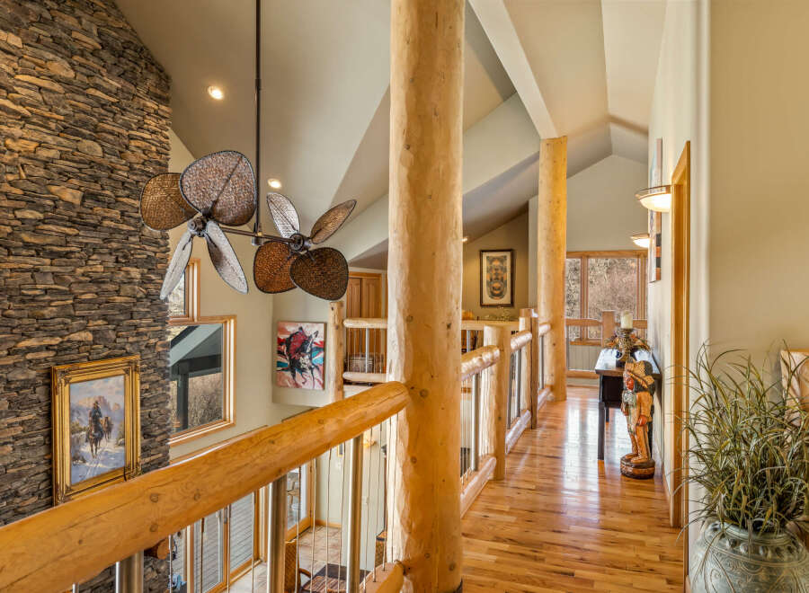 This stunning property boasts a grand entrance with a stone fireplace and a unique ceiling fan.