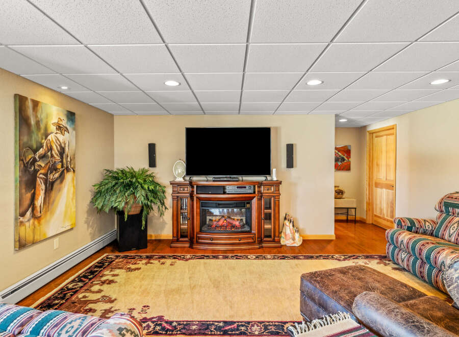 Step into this inviting living space, featuring a cozy fireplace and a large flat-screen TV, perfect for relaxing evenings.