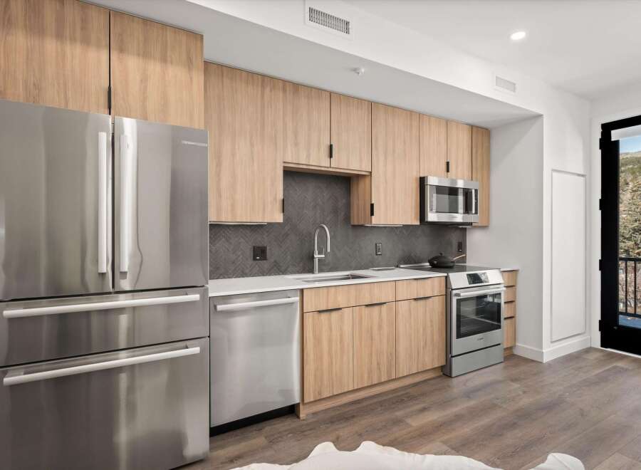 This modern kitchen boasts sleek stainless steel appliances, including a refrigerator, dishwasher, and oven.