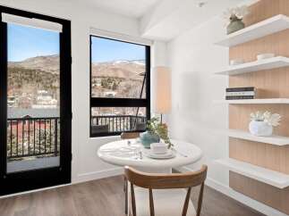 Enjoy breathtaking mountain views from this stunning property! This bright and airy space features a modern dining area with a sleek table and stylish decor.
