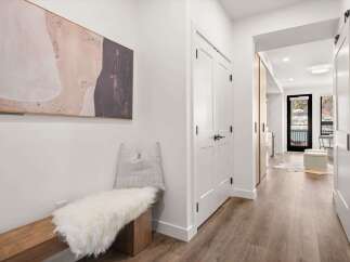Step into this stunning property and be greeted by a modern hallway with a beautiful artwork and a cozy bench.