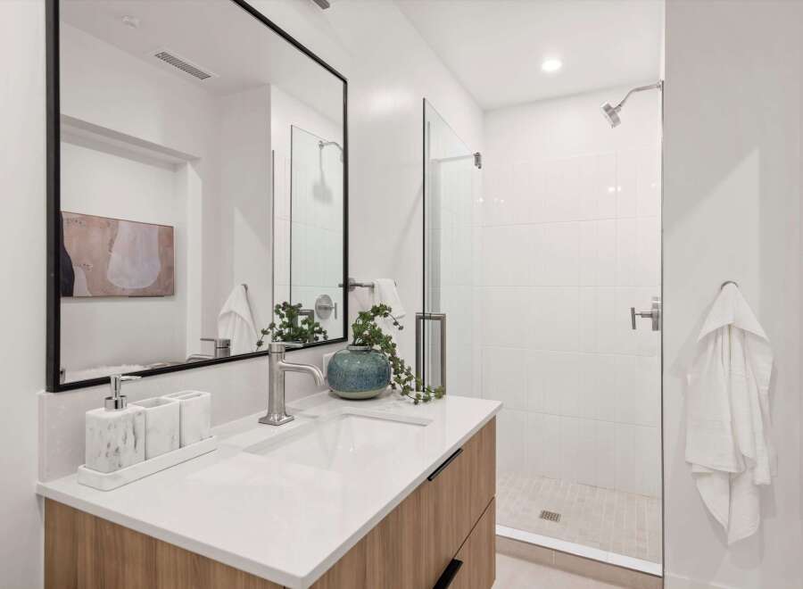 This modern bathroom features a sleek design with a spacious walk-in shower and a stylish vanity.