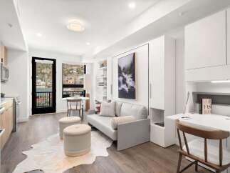 Experience modern living in this stylish apartment featuring a sleek kitchen, a comfortable living area, and a convenient desk space.