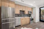 This modern kitchen boasts sleek stainless steel appliances, including a refrigerator, dishwasher, and oven.