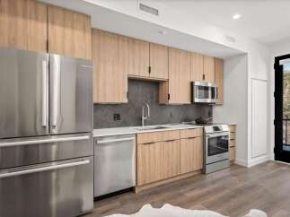 This modern kitchen boasts sleek stainless steel appliances, including a refrigerator, dishwasher, and oven.