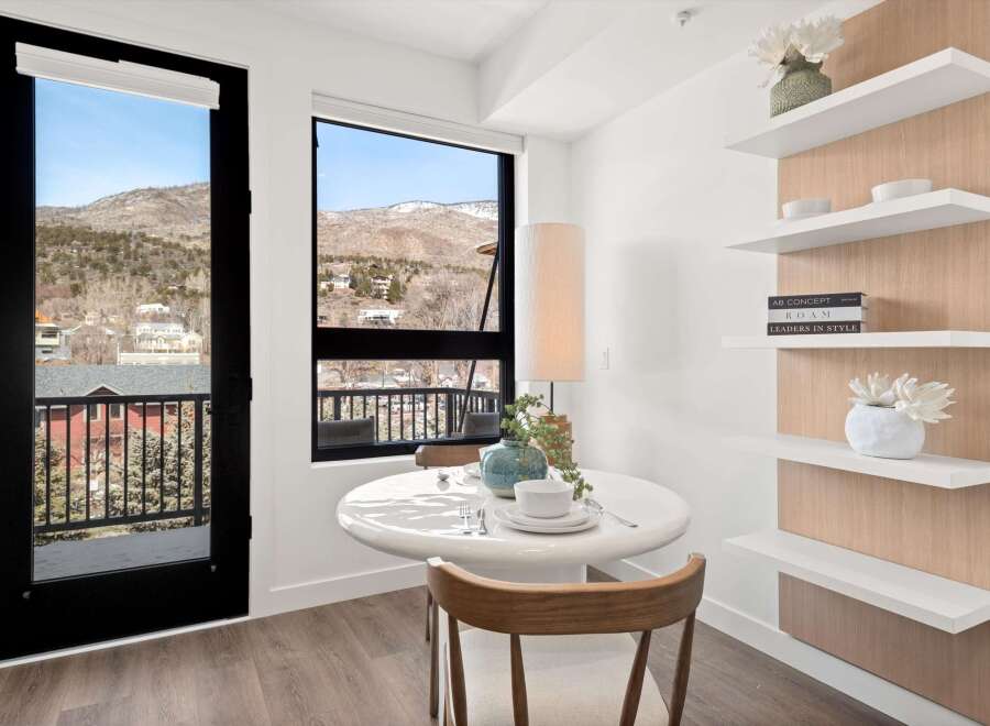 Enjoy breathtaking mountain views from this stunning property! This bright and airy space features a modern dining area with a sleek table and stylish decor.