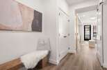 Step into this stunning property and be greeted by a modern hallway with a beautiful artwork and a cozy bench.