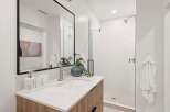 This modern bathroom features a sleek design with a spacious walk-in shower and a stylish vanity.