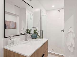 This modern bathroom features a sleek design with a spacious walk-in shower and a stylish vanity.