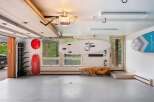 This spacious garage offers ample storage for your recreational gear, featuring a dedicated rack for surfboards or paddleboards and additional wall-mounted storage.