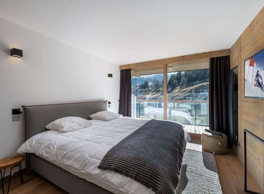 Experience luxury living in this stunning bedroom with breathtaking mountain views.