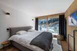 Experience luxury living in this stunning bedroom with breathtaking mountain views.