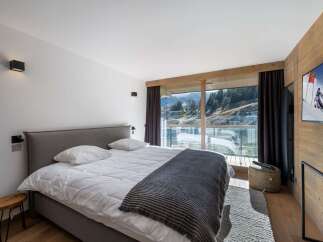 Experience luxury living in this stunning bedroom with breathtaking mountain views.
