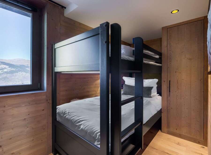 This cozy bedroom features a stylish bunk bed, perfect for accommodating guests or family members.