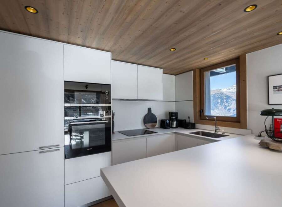 This modern kitchen boasts sleek white cabinetry and a minimalist design, perfect for a contemporary home.