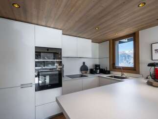 This modern kitchen boasts sleek white cabinetry and a minimalist design, perfect for a contemporary home.